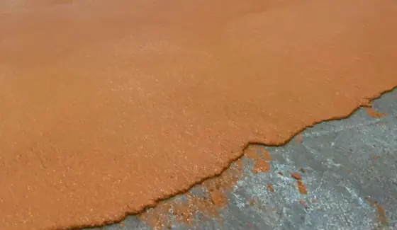 Turuncu poliüretan beton kaplamanın bittiği serme sınırı ve yanındaki ham beton