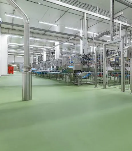Fabrika üretim salonunda yeşil poliüretan beton zemin, kolonlar ve makine hattı