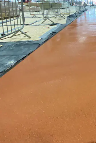Kaplama öncesi ham beton zemin ve inşaat bariyerleriyle ayrılmış çalışma alanı