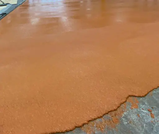 Endüstriyel bir hacimde uygulanmış turuncu poliüretan beton yüzey