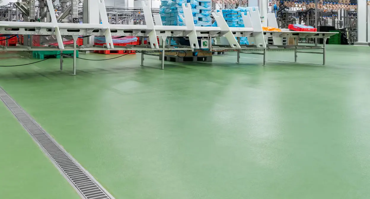 Gıda tesisinde açık yeşil poliüretan beton zeminin çizgi süzgeç çevresindeki geniş yüzeyi