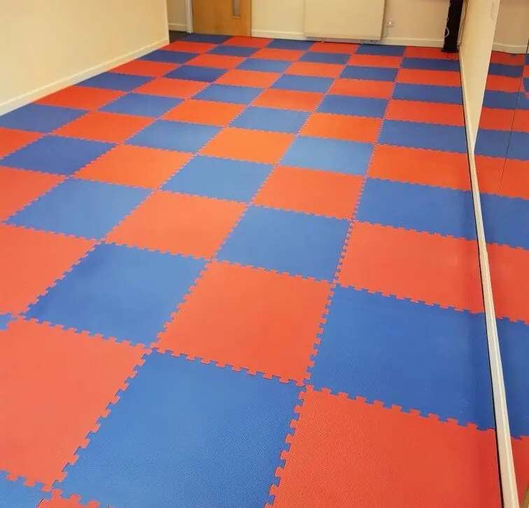 Salon zemininde geçmeli döşenmiş kırmızı ve mavi tatami minderler